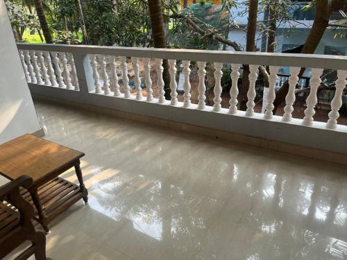 a balcony with a wooden bench and a railing at Tender Coconut in Morjim