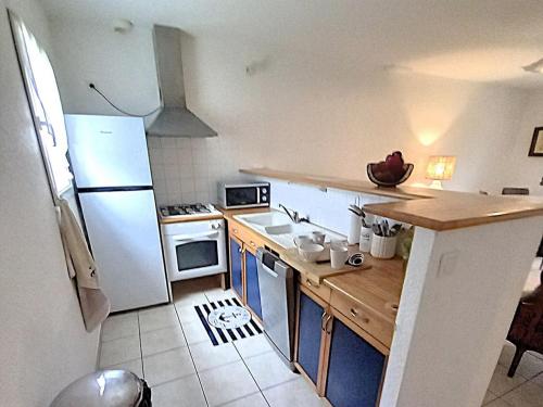 une cuisine avec un réfrigérateur blanc et un évier dans l'établissement Petite maison proche plage à Penvins, idéale pour familles - FR-1-639-134, à Sarzeau