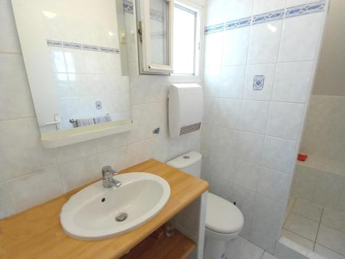 une salle de bain blanche avec un lavabo et des toilettes dans l'établissement Petite maison proche plage à Penvins, idéale pour familles - FR-1-639-134, à Sarzeau