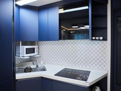 a blue kitchen with a sink and a microwave at Stay Hankan 모던코리아라이프 in Seoul