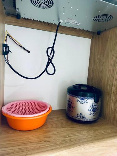 a pot and a bowl sitting on a shelf at Trang Dream House Phan Rang in Kinh Dinh