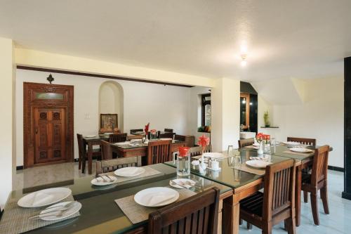 a dining room with a table and some chairs at Maharshis Guddethota Homestay in Chikmagalur