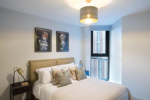 a bedroom with a bed with pillows and a window at Duet Manchester in Manchester