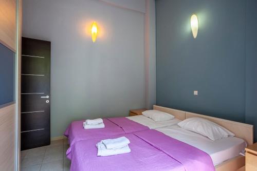 a bedroom with a purple bed with towels on it at Viorelis Sea View Villa in Kassandra
