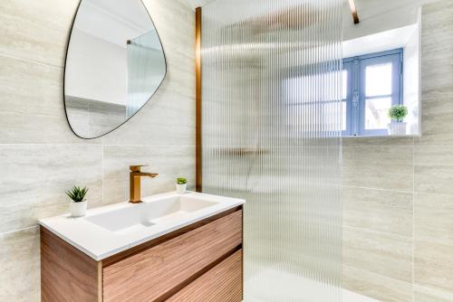 une salle de bain avec un lavabo et un miroir dans l'établissement L'Escapade - Parking Gratuit - WIFI - Climatisation - Proche Cité - Tout Equipée, à Carcassonne