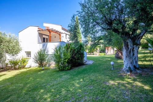 a tree in a yard next to a house at Viorelis Sea View Villa in Kassandra