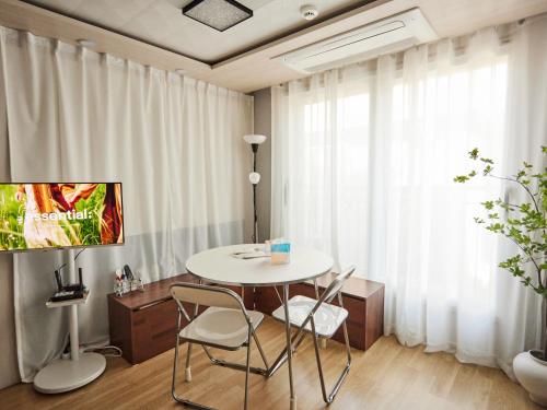 a table and chairs in a room with a window at Stay Hankan 모던코리아라이프 in Seoul