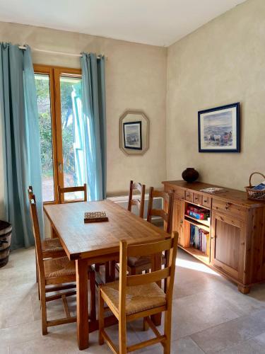 a dining room with a wooden table and chairs at Maison Stony - Gîtes & Vignoble in Frontignan