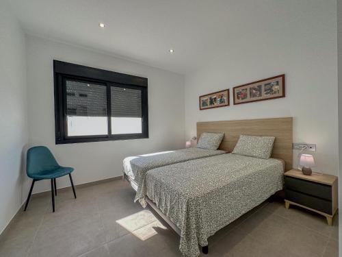 a bedroom with a bed and a chair and a window at Villamar 6 in San Pedro del Pinatar