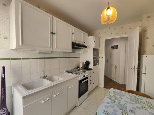 une cuisine avec des armoires blanches et un évier dans l'établissement Chez Jeanjean, à Saint-Malo