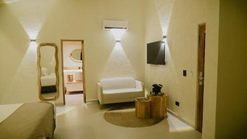 a bedroom with a bed and a mirror and a chair at Talam House Coveñas by Bernalo Hotels in Coveñas