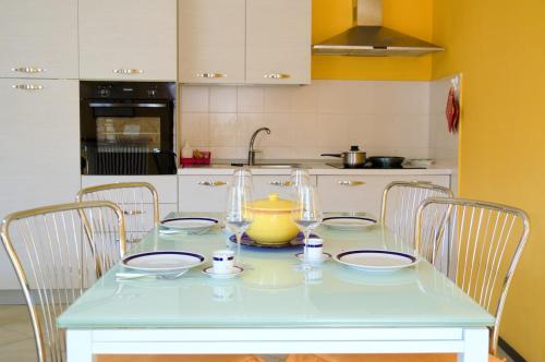 a kitchen with a table with chairs and a vase on it at Casa Gialla Soggiorno Panorama in Centro Storico in Dogliani
