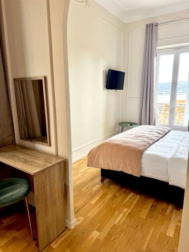 une chambre avec un lit, un miroir et une fenêtre dans l'établissement Hotel La Citadelle, à Villefranche-sur-Mer