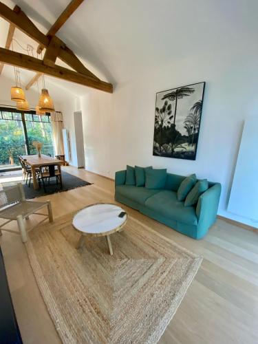 un salon avec un canapé bleu et une table dans l'établissement Villa Des Écureuils Pyla-sur-Mer, à La Teste-de-Buch