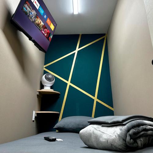 a bedroom with a wall with a tv and a bed at Cabina Dormitorio Polanco MP 1 in Mexico City