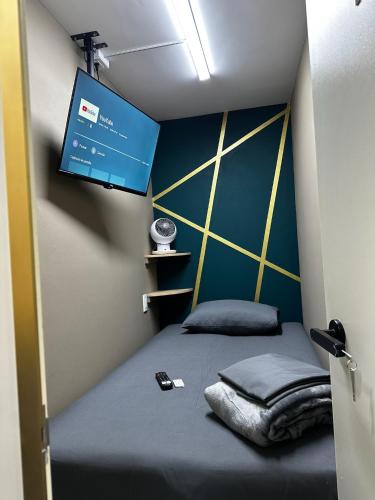 a small room with a bed with a tv on the wall at Cabina Dormitorio Polanco MP 1 in Mexico City