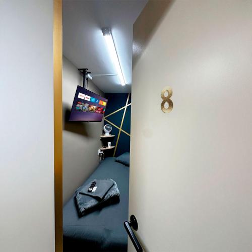 a small room with a bed and a television at Cabina Dormitorio Polanco MP 1 in Mexico City