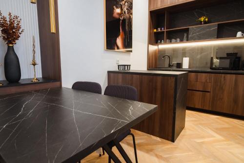 a kitchen with a black marble table and chairs at Royal Central Apartments in Zagreb