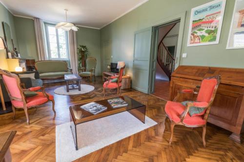 a living room with red chairs and a piano at Jouandeou in Donzacq