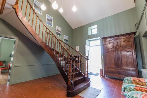 a wooden staircase in a room with a wooden door at Jouandeou in Donzacq