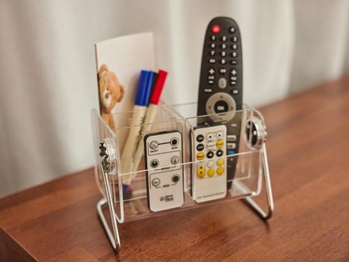 a glass container with remote controls on a table at Stay Hankan 모던코리아라이프 in Seoul
