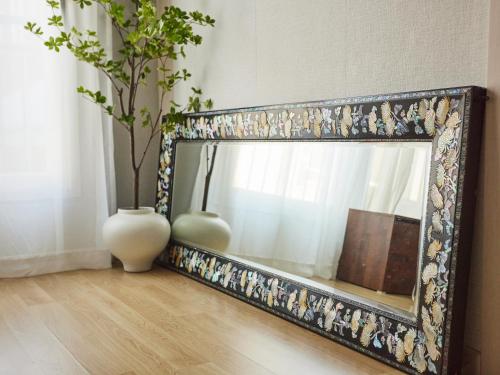 a mirror with two vases sitting next to a window at Stay Hankan 모던코리아라이프 in Seoul