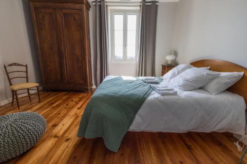 a bedroom with a large bed with a wooden floor at Jouandeou in Donzacq