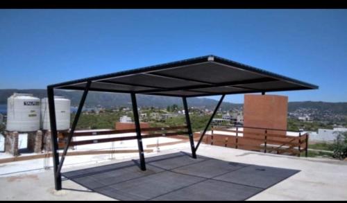 een zwarte luifel bovenop een gebouw met banken bij Apartamento Lomados in Villa del Lago