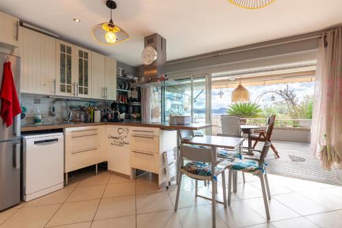 une cuisine avec une table et des chaises ainsi qu'une salle à manger dans l'établissement Les pieds dans l'eau, à La Ciotat