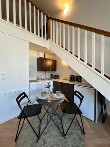 une cuisine et une salle à manger avec une table et deux chaises dans l'établissement Appartement à 2km de Disneyland Paris, à Montévrain