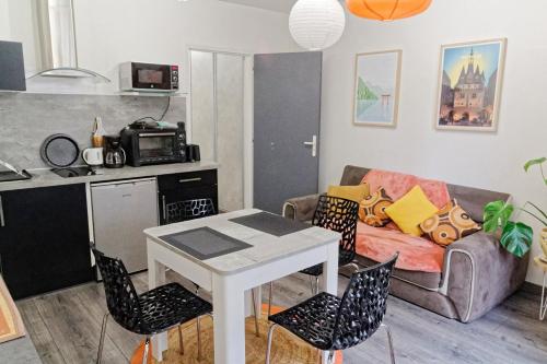Una sala de estar con un sofá, una mesa y sillas. en Appartement avec vue rue Ste Catherine, en Burdeos
