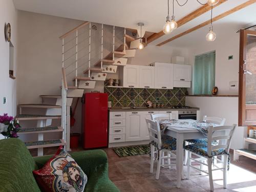 Una cocina con una mesa y un refrigerador rojo. en Da Giorgia, en Forza dʼAgro