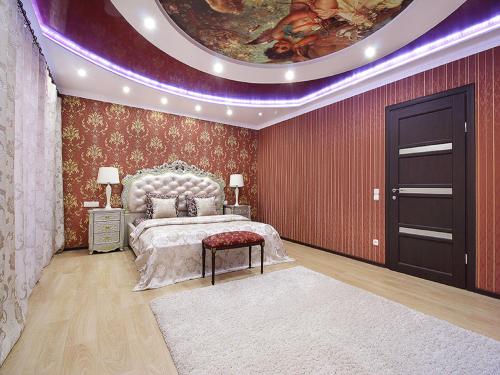 una camera da letto con un letto e un dipinto sul muro di PaulMarie Apartments on Mayakovskogo a Brest