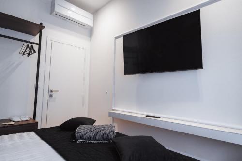 a bedroom with a flat screen tv above a bed at Royal Central Apartments in Zagreb
