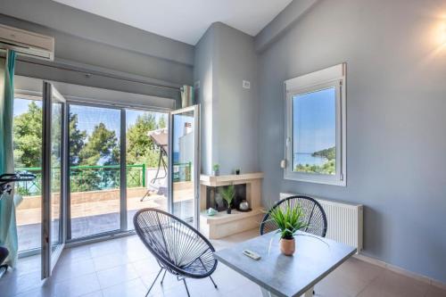 a living room with a table and chairs and a balcony at Viorelis Sea View Villa in Kassandra