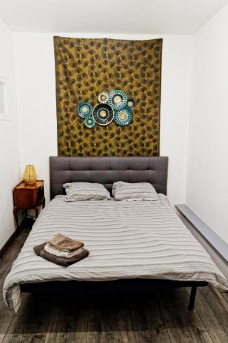un lit dans une chambre avec un tableau sur le mur dans l'établissement Appartement avec vue rue Ste Catherine, à Bordeaux
