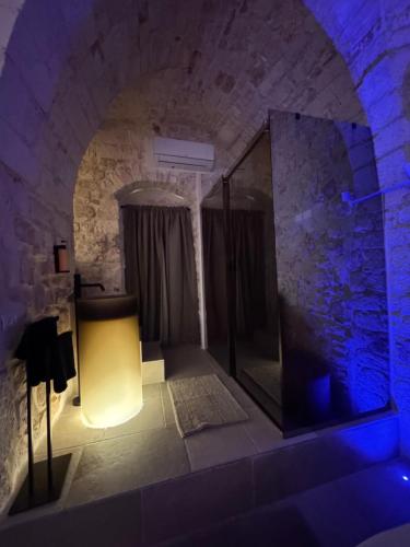 a dark room with a shower in a stone wall at Elite Suite in Castellana Grotte