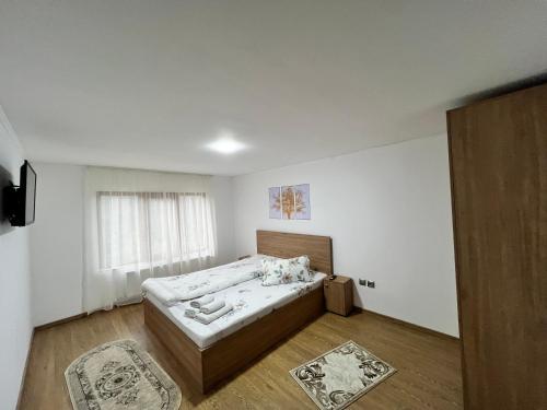 a bedroom with a bed in a room with a window at Casa Liniștea Munților in Fundata