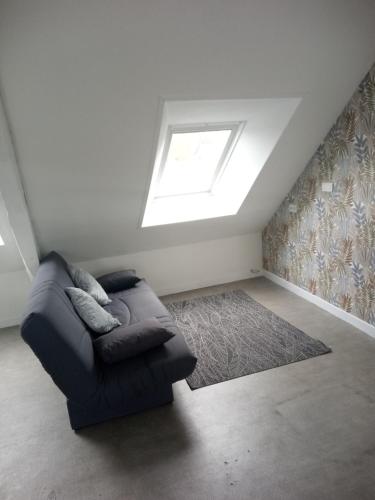 - un salon avec un canapé et une lucarne dans l'établissement STUDIO MEUBLE professionnel Fruges, à Fruges