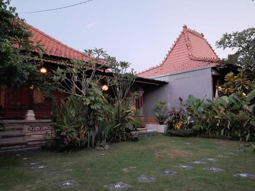 a house with a garden in front of it at Pondok Dauh Ancak Kelating Guest House in Krambitan