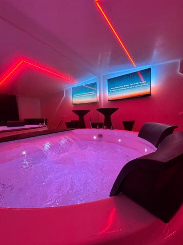 a hot tub in a room with red lights at Elite Suite in Castellana Grotte
