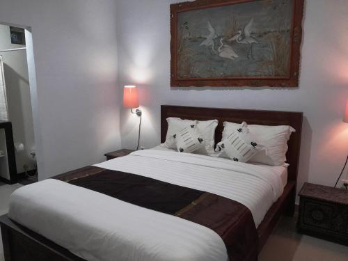 a bedroom with a large bed with white sheets and pillows at Pondok Dauh Ancak Kelating Guest House in Krambitan