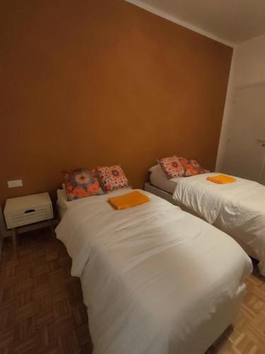 two beds in a room with orange towels on them at Casa di Pam in Vicenza