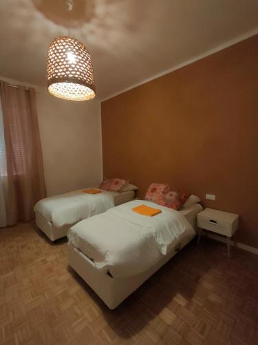a bedroom with two beds and a chandelier at Casa di Pam in Vicenza