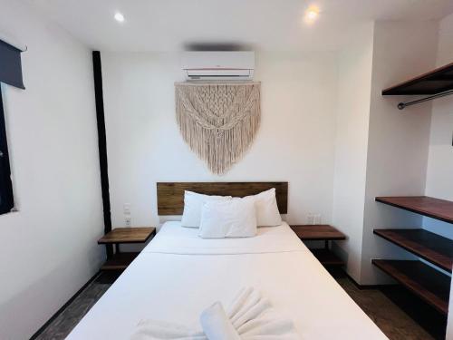 a bedroom with a large white bed and a chandelier at Coco Live Suites in Playa del Carmen