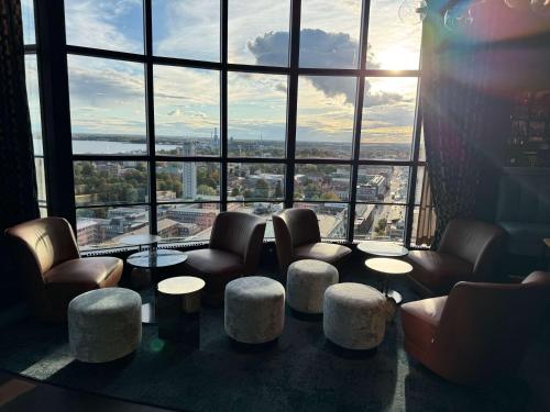 a room with chairs and tables in front of a large window at Best Western Plus Hotel Plaza in Västerås