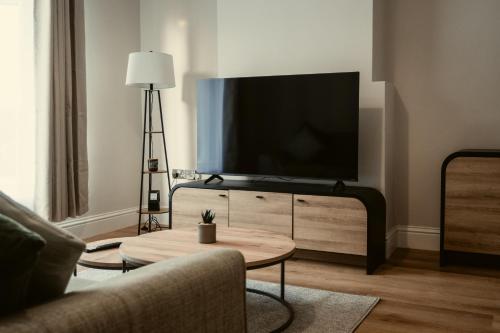 a living room with a flat screen tv on a dresser at George Florence House in Spennymoor