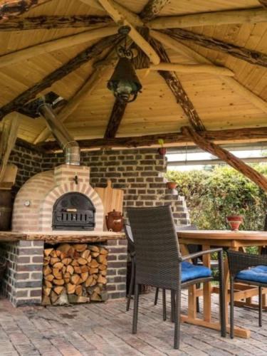 a patio with a brick oven with a table and chairs at Wohnung In Niedergurig Mit Grill, Sauna Und Garten in Malschwitz