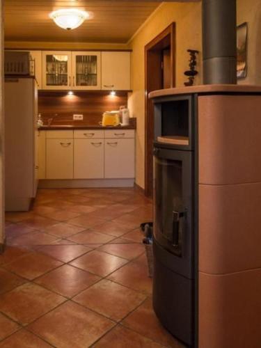 a kitchen with a stove in the middle of a room at Wohnung In Niedergurig Mit Grill, Sauna Und Garten in Malschwitz