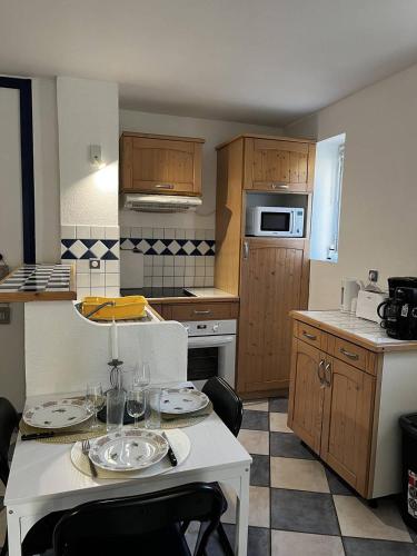 une cuisine avec une table avec des assiettes dessus dans l'établissement Appartement T2 à 50 m de la plage, proche des commodités, à Canet